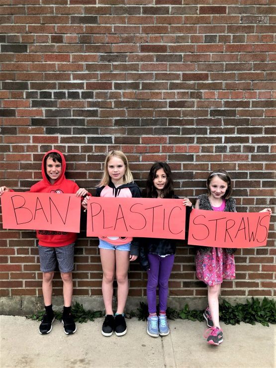 Students hold signs calling for ban on plastics