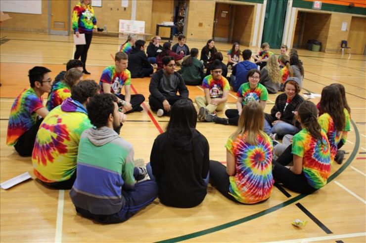 A group of students works on a team-building activity in a gym