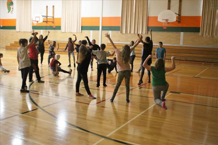 Students participate in a dance class in a school gymnasium 