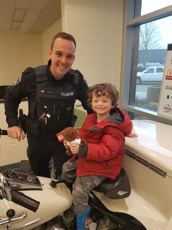 A police officer poses with a young student