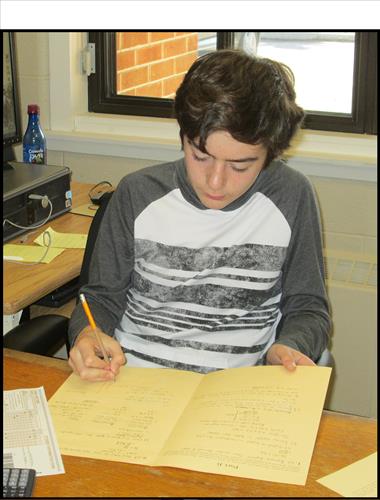 A male student writes in a notebook