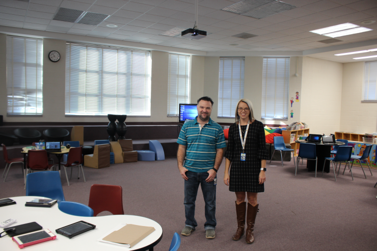 Two teachers stand among the Learning Commons space