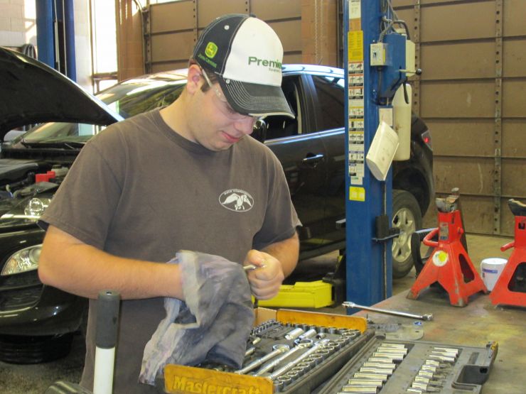 A student works in an automotive mechanic shop