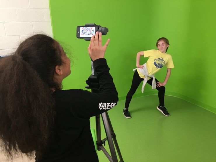 Two students use a green screen 