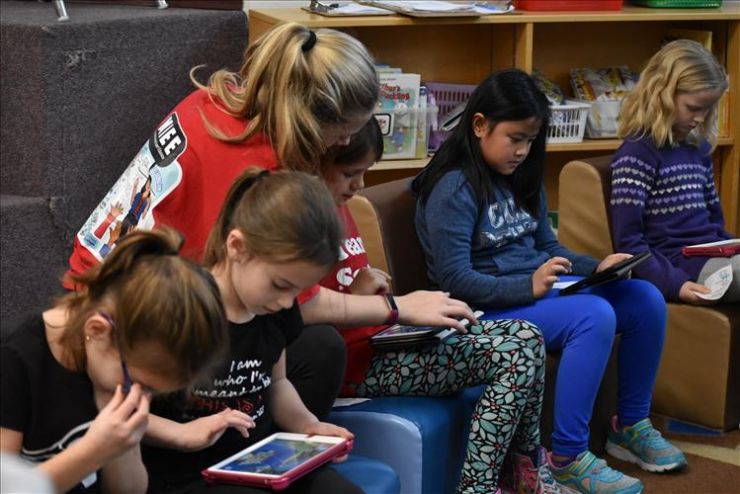 Students participate in a coding exercise on tablet devices in a learning commons 