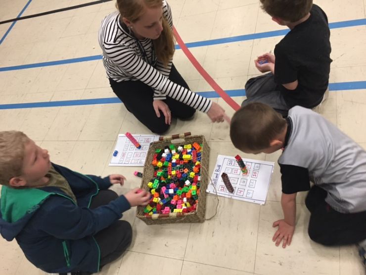 Students and parents use math manipulatives during a workshop