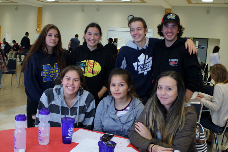 Seven student leaders pose at a table during an event