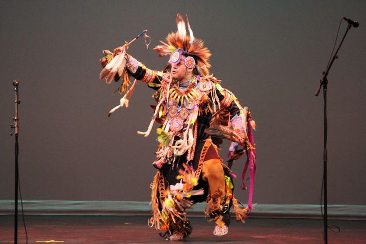 An Indigenous dancer performs on stage