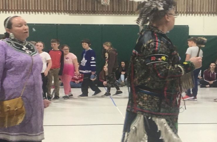 Indigenous dancers lead a group of students