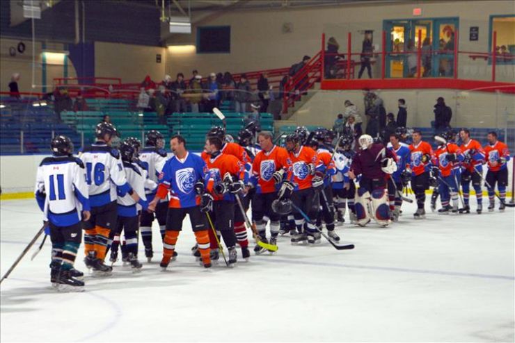 Two hockey teams shake hands on the ice