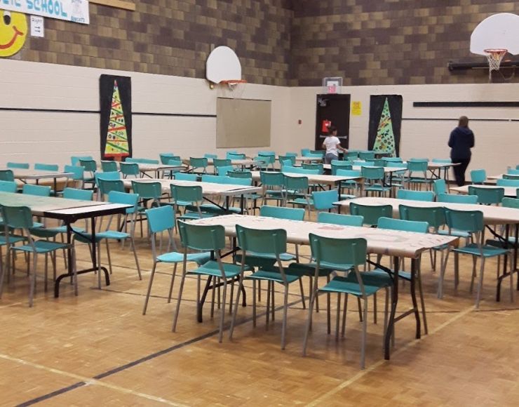 A school gym is transformed into a food hall with rows of tables and chairs