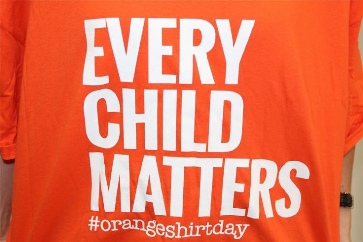A close-up image of an orange t-shirt displaying the phrase Every Child Matters