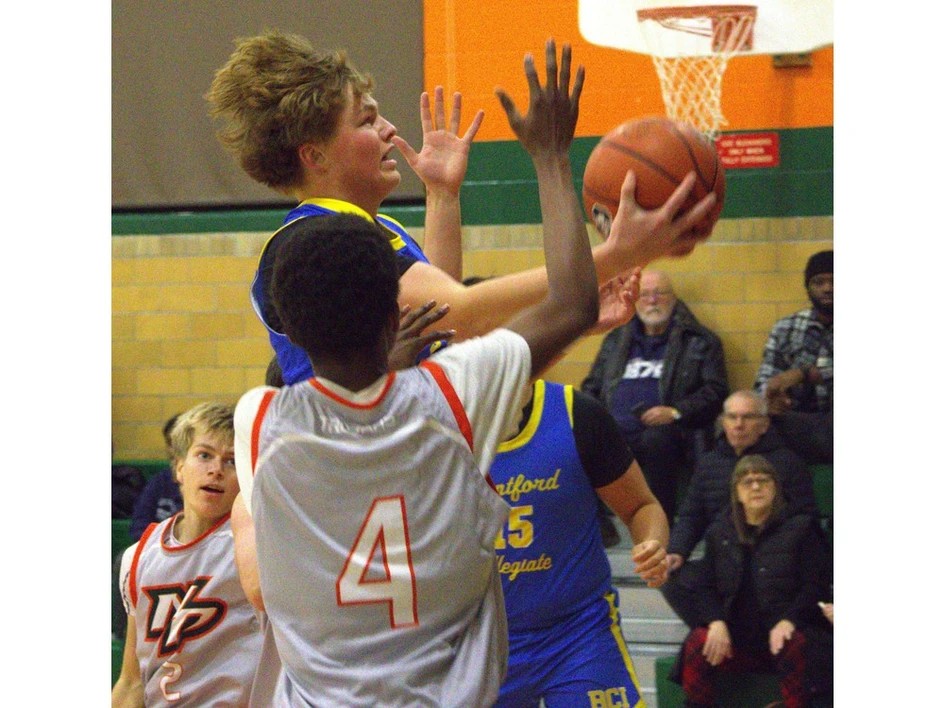 1206-br-hsbball1.br_ Brantford Collegiate Institute's Garrett Young drives past North Park Collegiate's Omari Barnes during AABHN senior boys basketball action at NPC on Thursday.