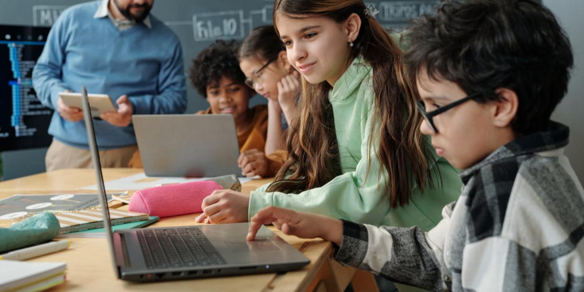 School children in classroom learning on a laptop