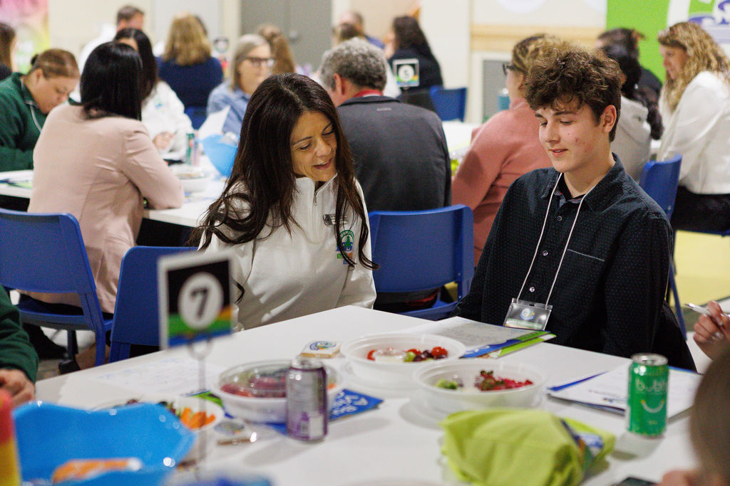 Two people sitting at group table examining paper